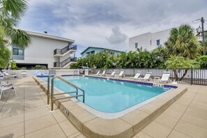 Ein Schwimmbecken mit einer Tiefe von 6 Fuß 6 Zoll, umgeben von Liegestühlen und einer Palme.