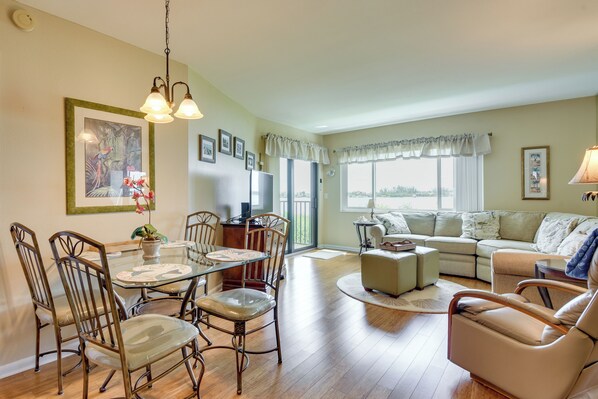 A spacious living area with a dining table, chairs, a sofa, and a television. - Steps to Sand! Extended Bradenton Beach Getaway (Bradenton Beach)