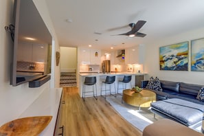 Una cocina moderna con una isla central, taburetes de bar y un ventilador de techo.