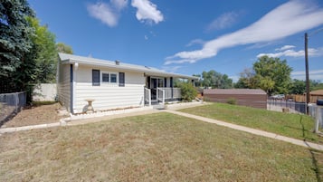 A single-story mobile home with a front porch and a fenced yard.