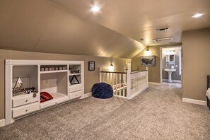 A hallway with a white staircase, a blue ottoman, and a wall with a map of the United States. - Walk to Texas Tech! Upscale Family Retreat (Lubbock)