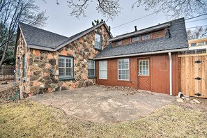 A stone house with a stone exterior, a red door, and a covered patio area. - Walk to Texas Tech! Upscale Family Retreat (Lubbock)
