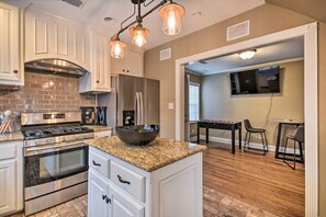 A modern kitchen with stainless steel appliances, a granite countertop, and pendant lighting. - Walk to Texas Tech! Upscale Family Retreat (Lubbock)