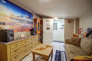 Ein Wohnzimmer mit einem großen Gemälde, Holzmöbeln, einer Tür mit einem Schild und einer Wanduhr.