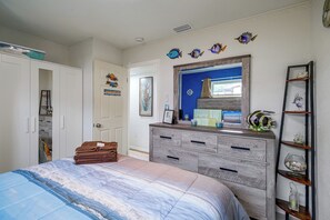 Ein Schlafzimmer mit einem Bett, einem Schminktisch und Regalen mit Dekorationen.