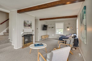 A living room with a fireplace, seating area, and a television.