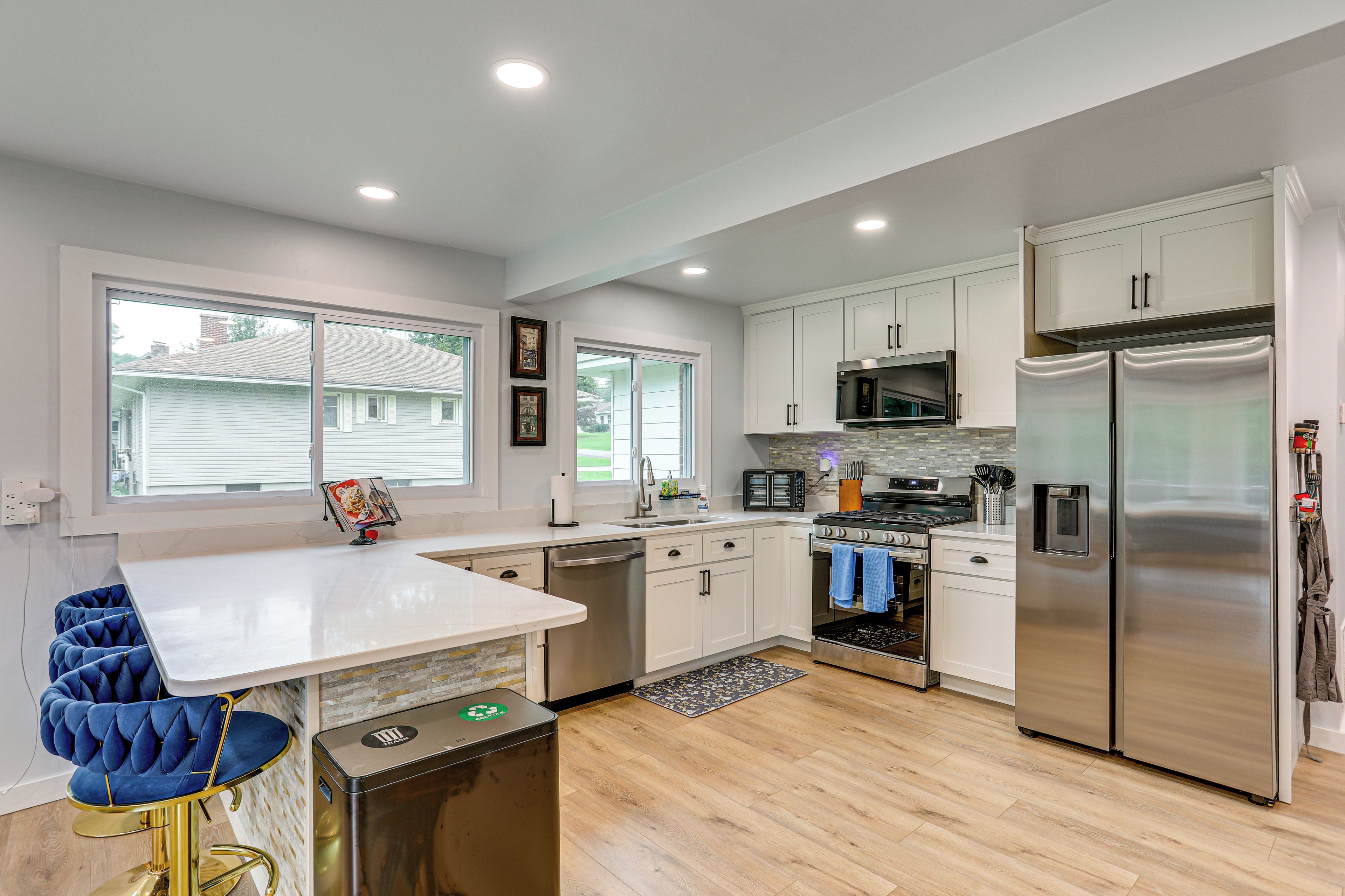 A modern kitchen with white cabinetry, stainless steel appliances, and a central island.
