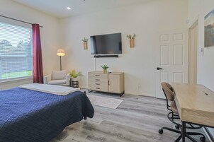 Un dormitorio con cama, escritorio, silla, televisor y armario.