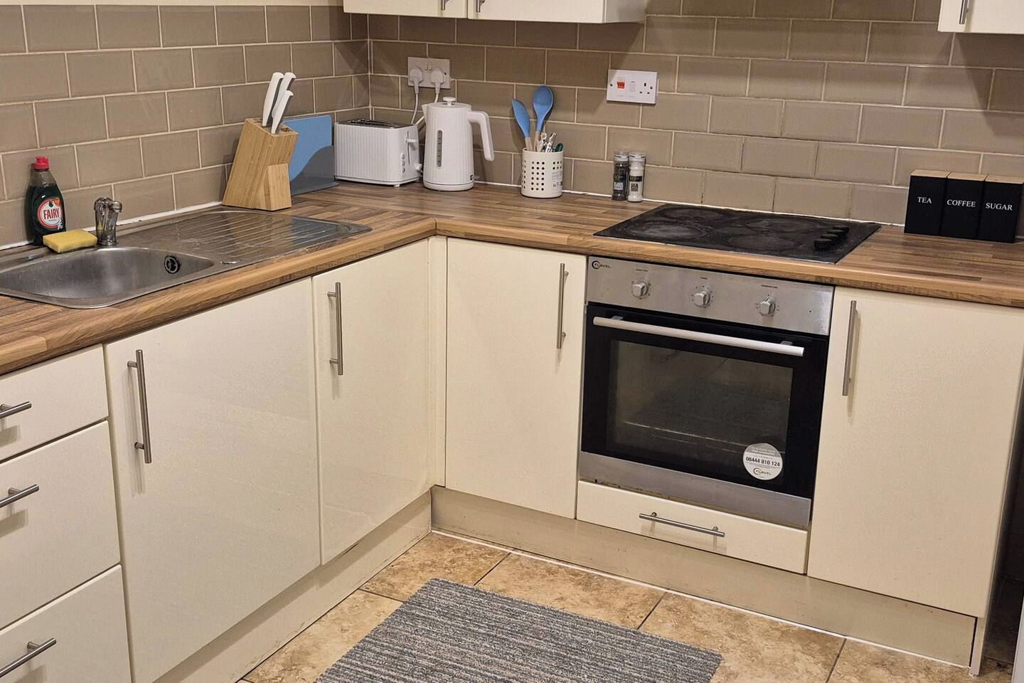 A kitchen with a built-in oven, a sink, and a coffee maker.