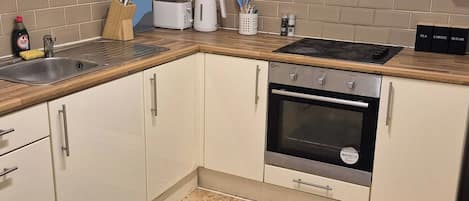 A kitchen with a built-in oven, a sink, and a coffee maker.