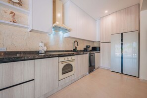 Eine moderne Küche mit Einbauofen, Geschirrspüler und Kühlschrank.