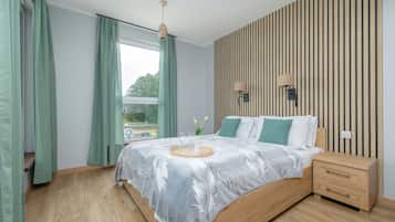 Ein modernes Schlafzimmer mit einem hölzernen Bett, einem Nachttisch, einem Fenster mit Vorhängen und einer Wandleuchte.