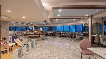 A spacious indoor area with a children's play area, a central bar, and seating arrangements.