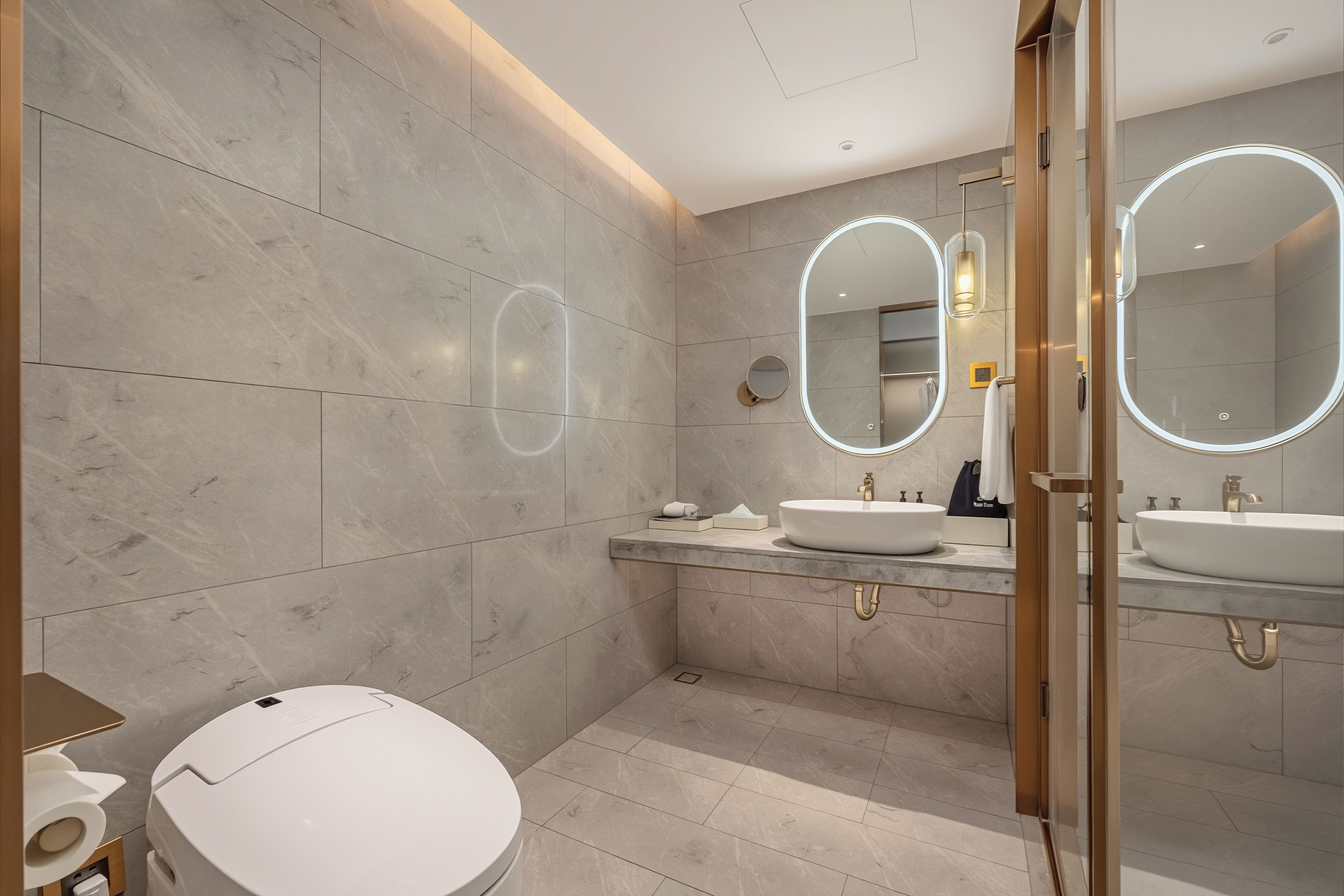 A modern bathroom with two sinks, a toilet, and a shower area.