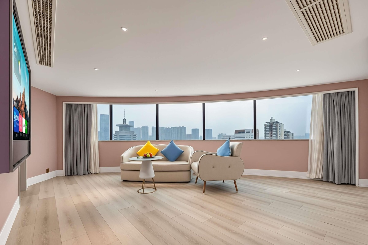 Amplia sala de estar con vista a la ciudad, televisor de pantalla plana y muebles modernos.