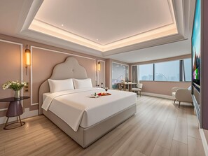 Una habitación de hotel moderna con una cama grande, un escritorio y vistas a la ciudad.