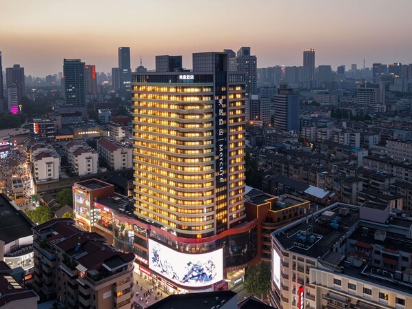 Un edificio de gran altura con varios pisos, rodeado de un entorno urbano denso.