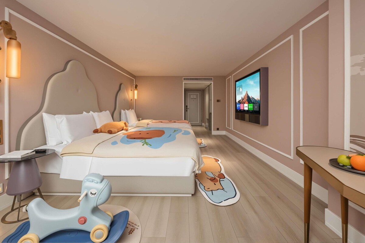 Una habitación de hotel con cama, televisor, escritorio y silla.