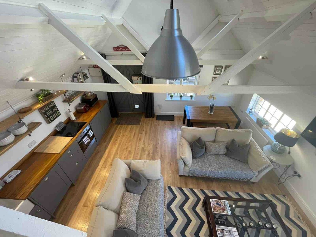 A spacious loft with a kitchen, dining area, and seating.