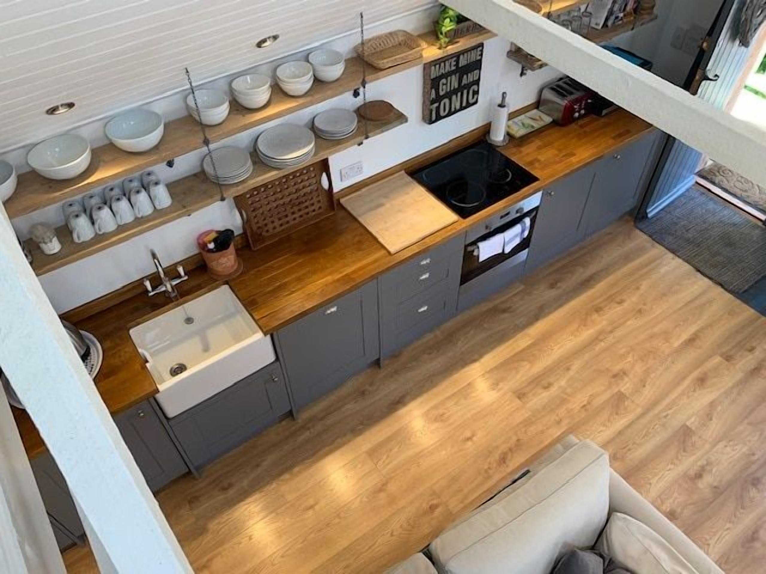 A modern kitchen with a wooden countertop, grey cabinets, and a built-in oven.