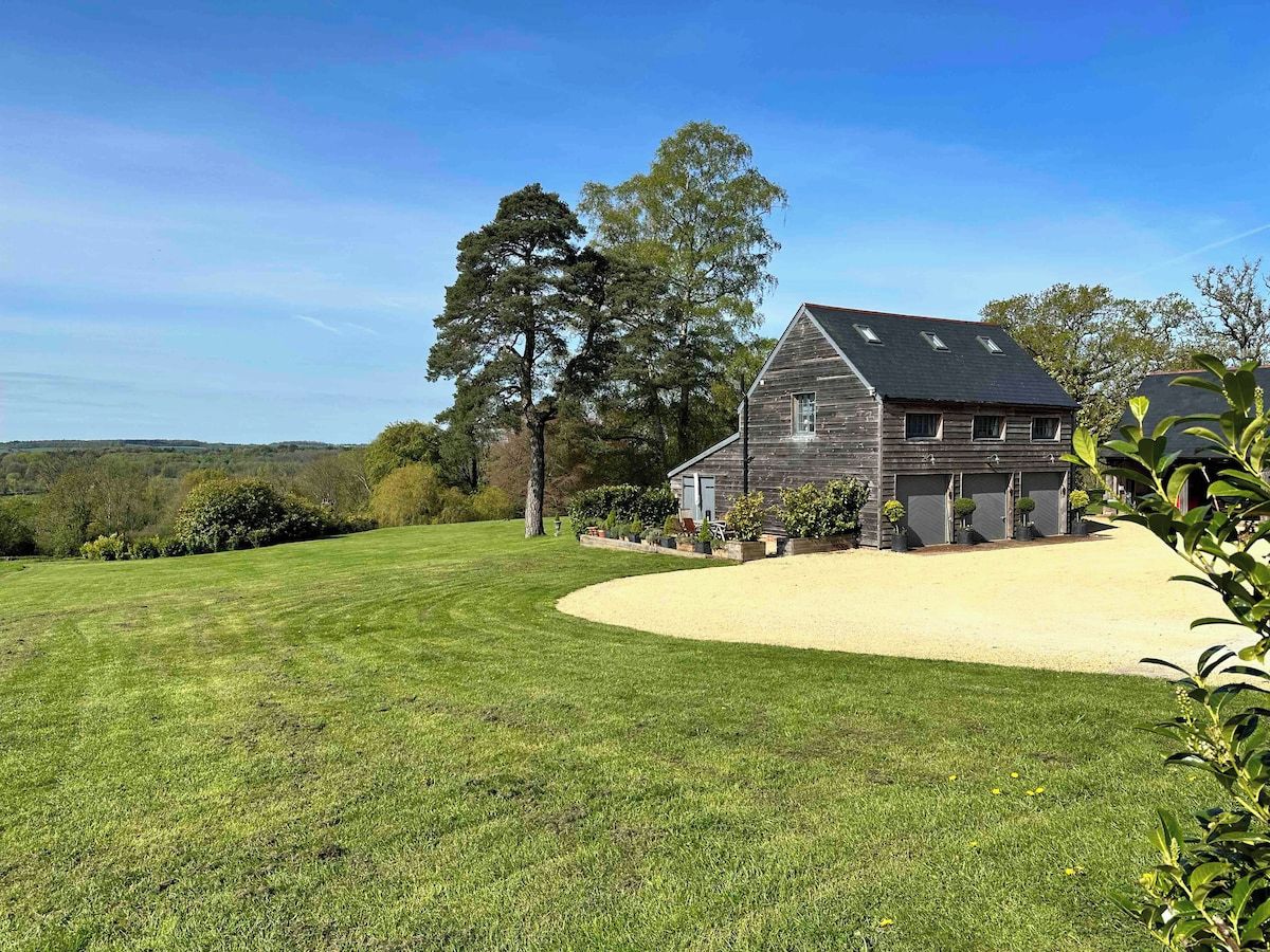 A house with a large lawn, a garage, and a driveway.