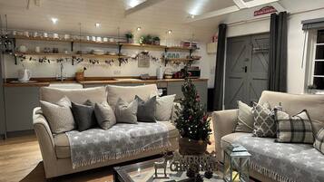 Ein gemütliches Wohnzimmer mit zwei Sofas, einem Couchtisch und einem Weihnachtsbaum.