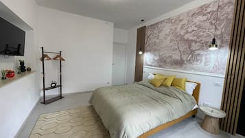 Un dormitorio moderno con cama, mesita de noche, estante montado en la pared y alfombra con diseño geométrico.