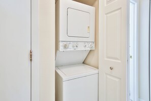 A laundry room with a washing machine and dryer, a control panel with various settings, and a door leading to another room. - 15 Min from AMI Beaches, Pickleball, Basketball. Free WIFI (Bradenton)