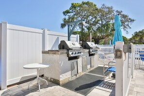 An outdoor patio with a grill station, a small table, and a pool area. - 15 Min from AMI Beaches, Pickleball, Basketball. Free WIFI (Bradenton)