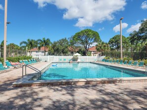 A rectangular swimming pool with a tiled deck, surrounded by lounge chairs and a white fence. - 15 Min from AMI Beaches, Pickleball, Basketball. Free WIFI (Bradenton)