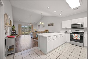 A modern kitchen with white cabinetry, a large island, and a built-in oven. - Golf Resort Condo, Pool, Near Broadway Beach (Myrtle Beach)