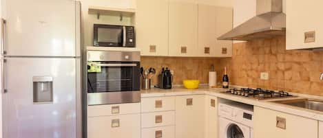 A modern kitchen with stainless steel appliances, a built-in oven, microwave, and a gas stove.