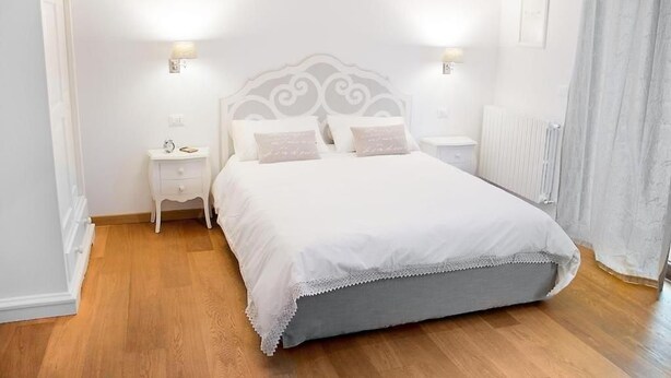 Une chambre à coucher avec un lit, des tables de chevet et un radiateur.