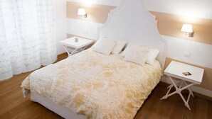 Une chambre à coucher avec un grand lit, deux tables de chevet et une commode.