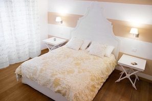 Un dormitorio con una cama grande, dos mesitas de noche y una mesilla.