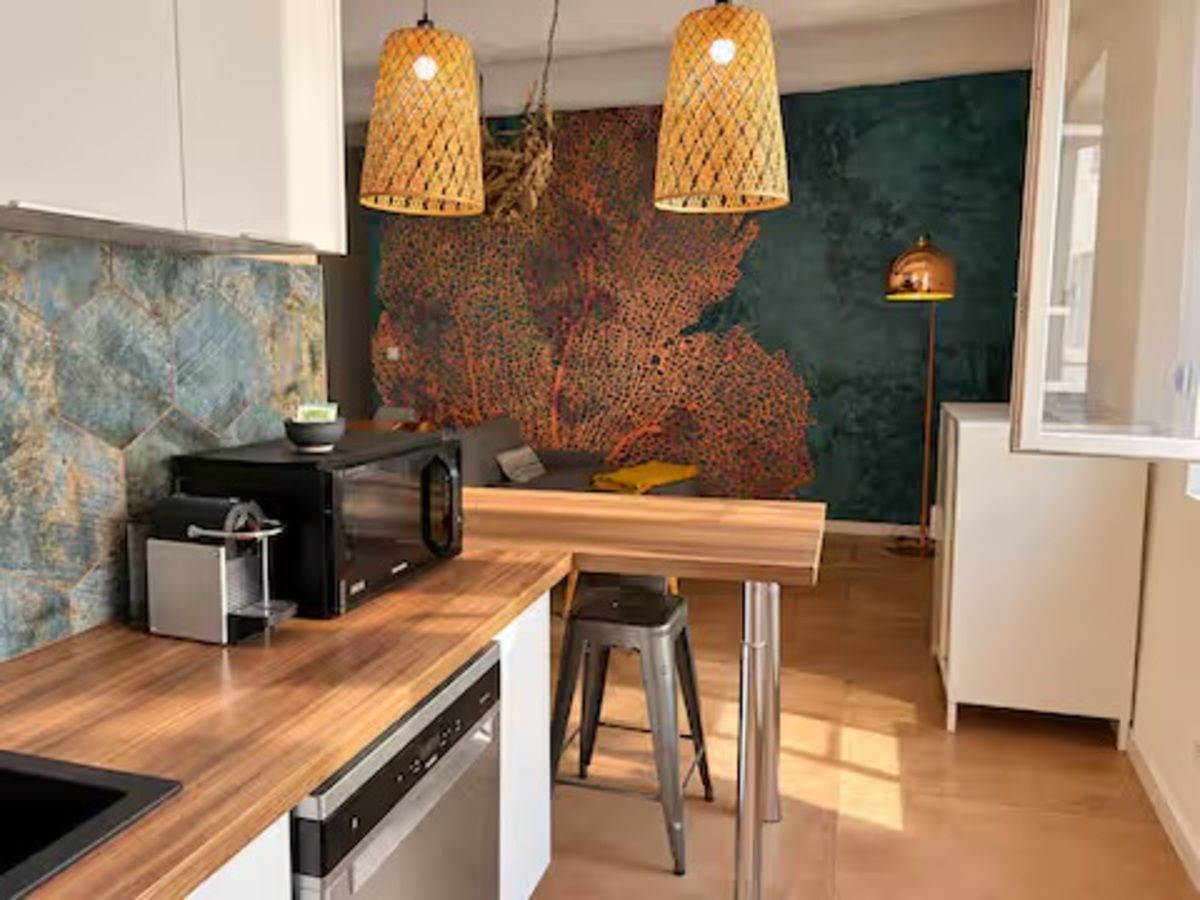 Une cuisine moderne avec un plan de travail en bois, des appareils en acier inoxydable et un coin bar.