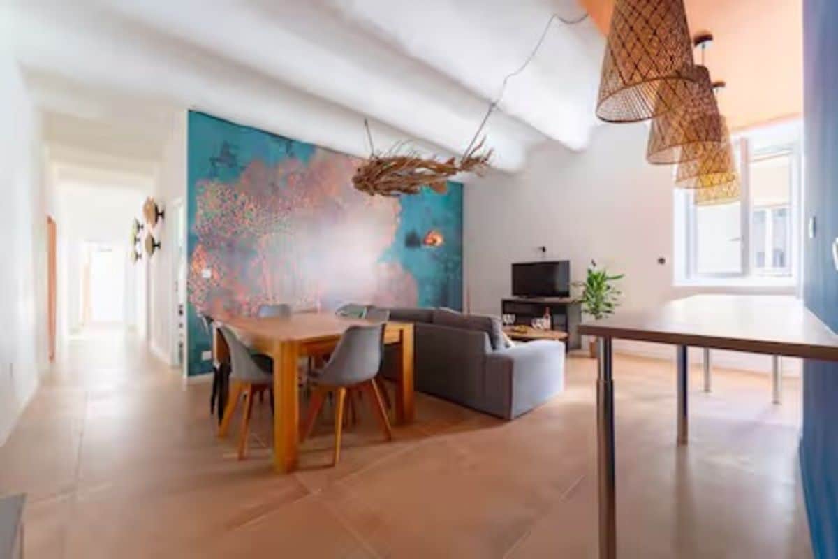 Un salon moderne comprenant un coin repas, une grande peinture abstraite et un téléviseur.