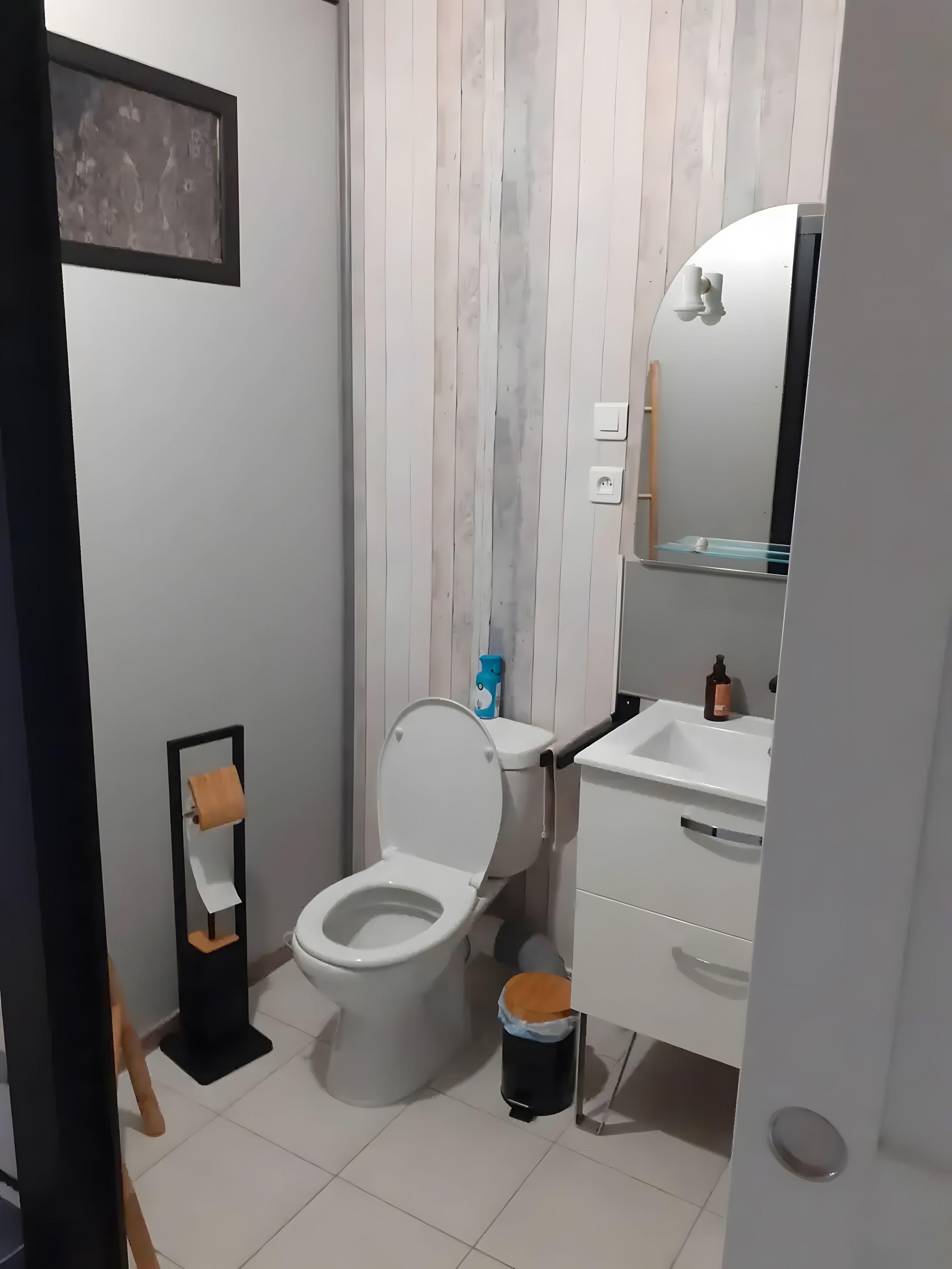 Une salle de bain moderne équipée de toilettes, d’un lavabo et d’un miroir.