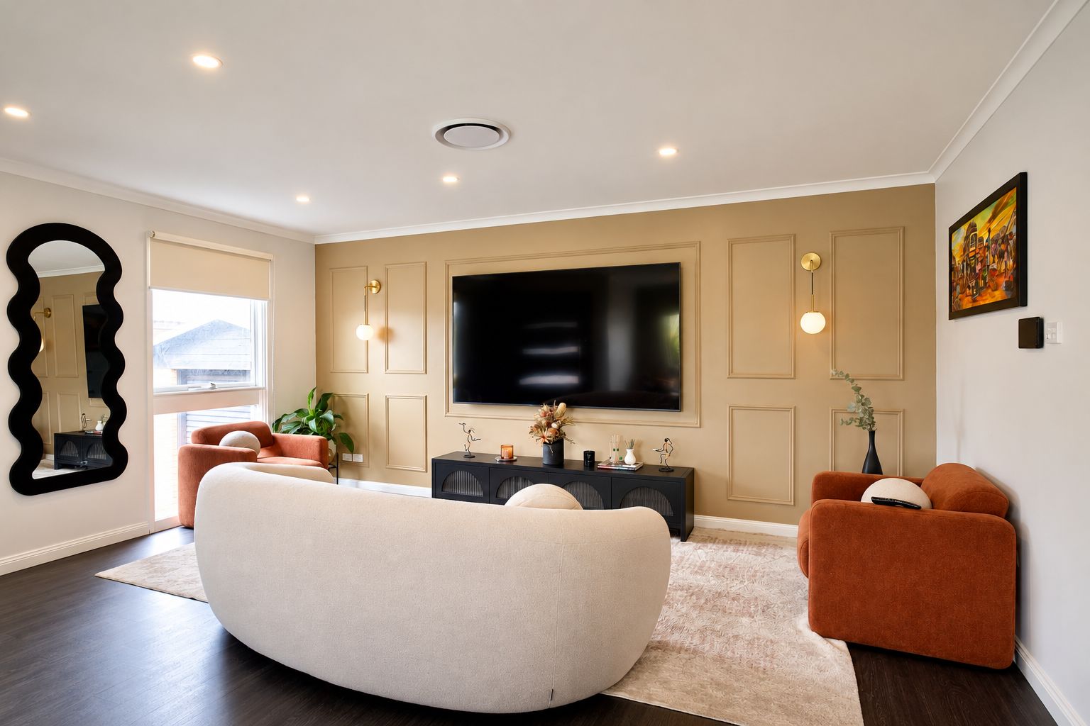 A modern living room with a large flat-screen TV, a sofa, a coffee table, and a side table with decorative items.