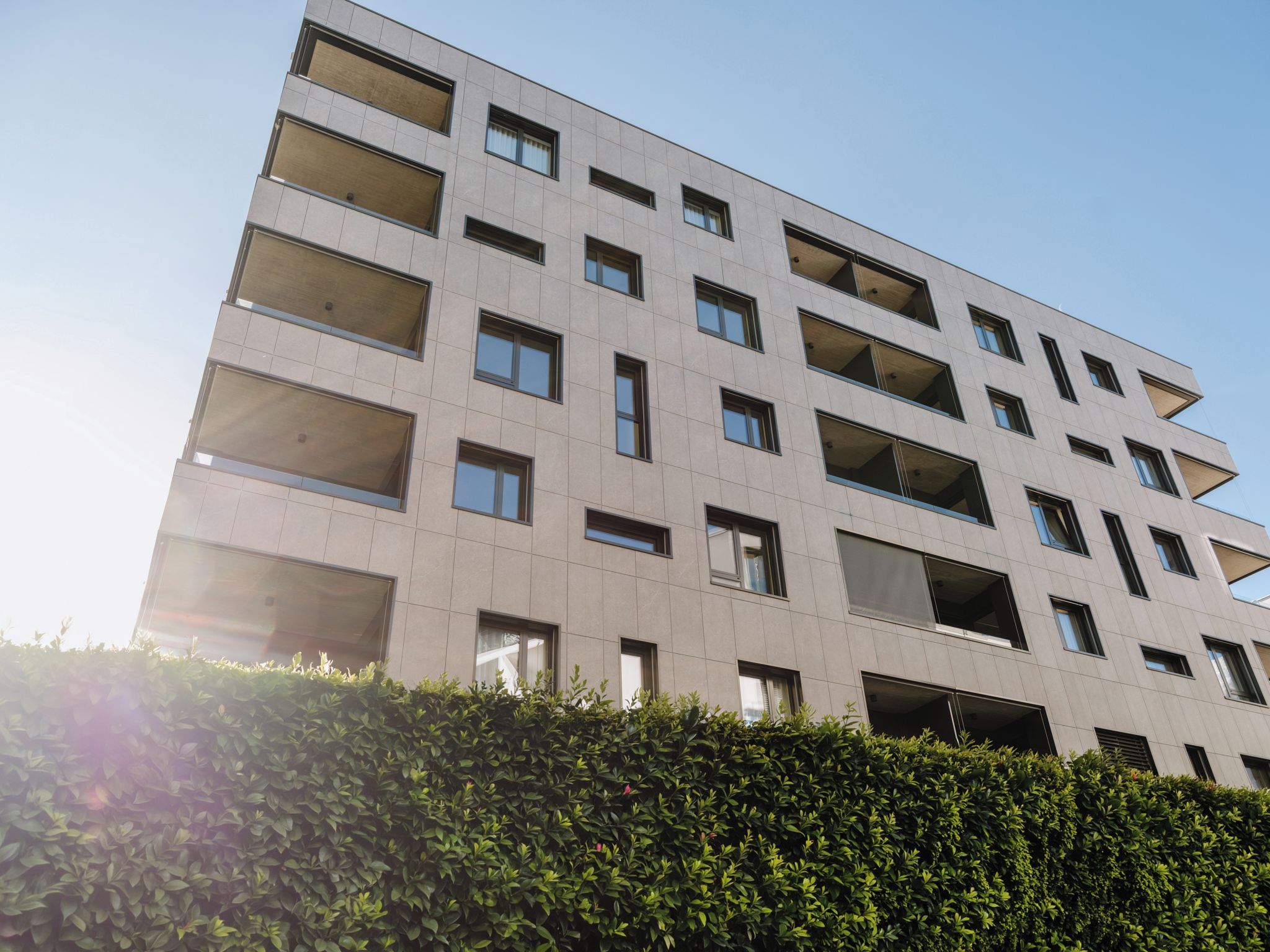 A multi-story building with a flat facade, numerous windows, and balconies.