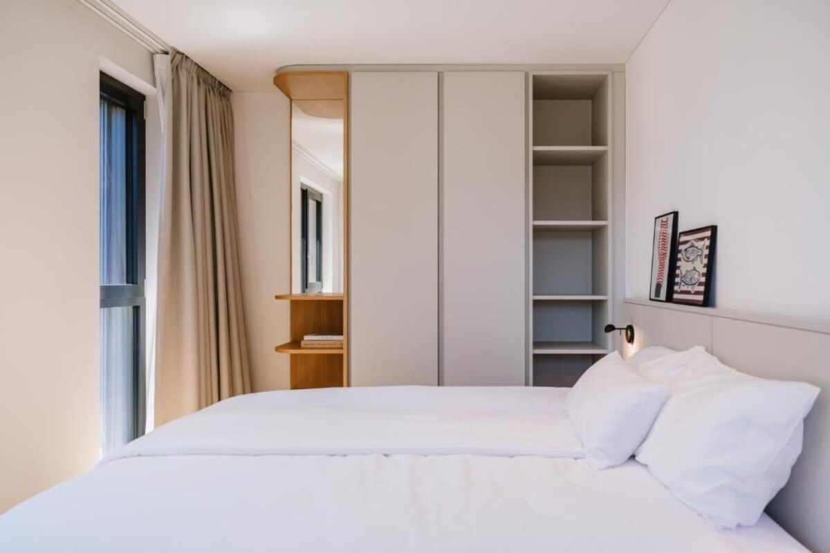 A bedroom with a bed, a wardrobe, and a shelf unit.