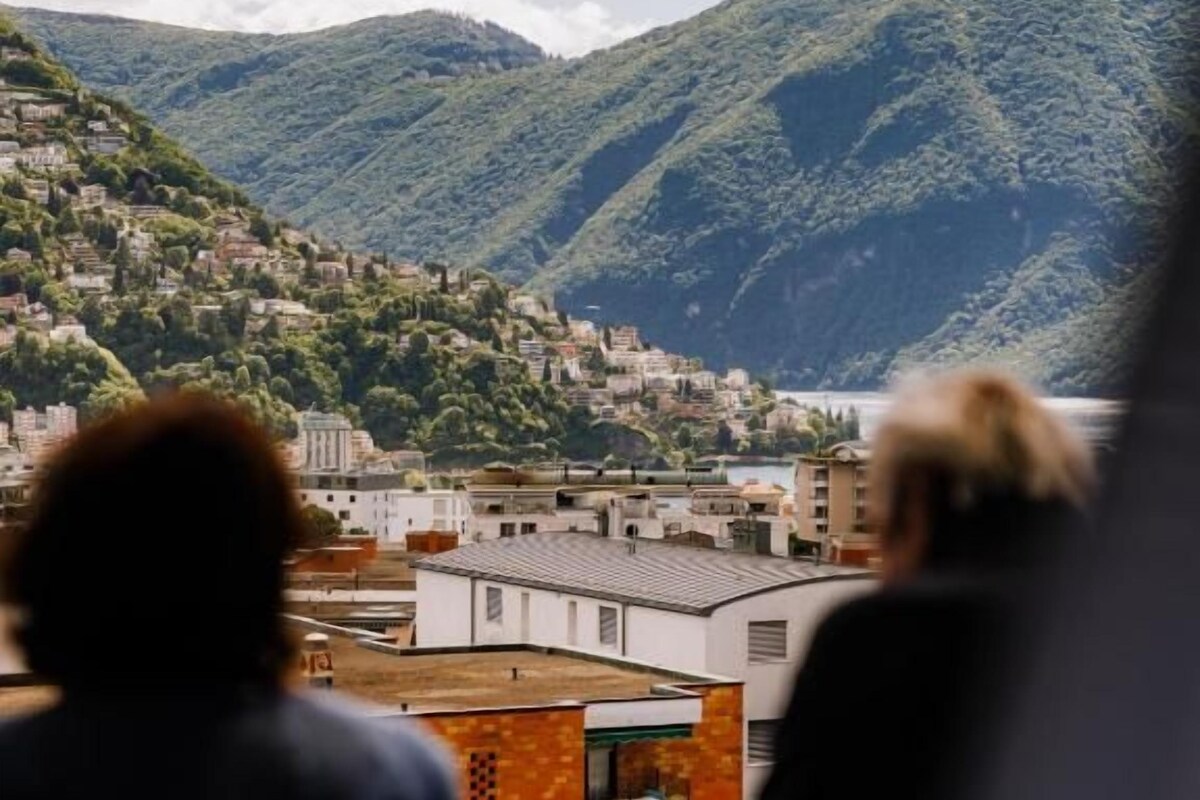 A view of a hillside town with buildings and a mountain backdrop.