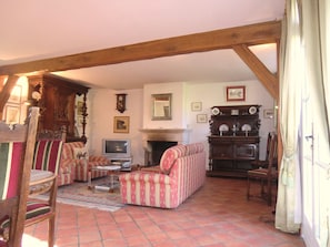 A traditional living room with a fireplace, a television, and a sofa set.