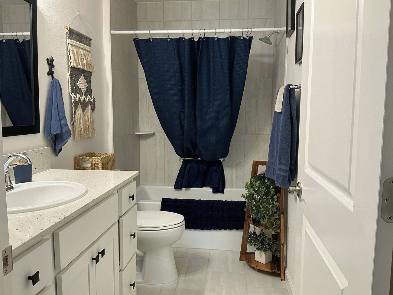 Une salle de bain avec un lavabo blanc, des toilettes, une baignoire et un rideau de douche.