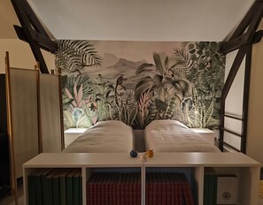 Een slaapkamer met een bed, een boekenkast en een muurschildering van een oerwoud.