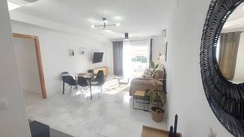 Una sala moderna con un sofá, una mesa de centro y una zona de comedor.