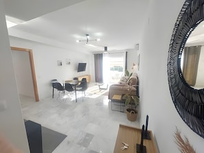 Un salon moderne avec un canapé, une table basse et un coin repas.