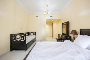 Una habitación de hotel con una cama grande, un escritorio con lámpara y un espejo en la pared.