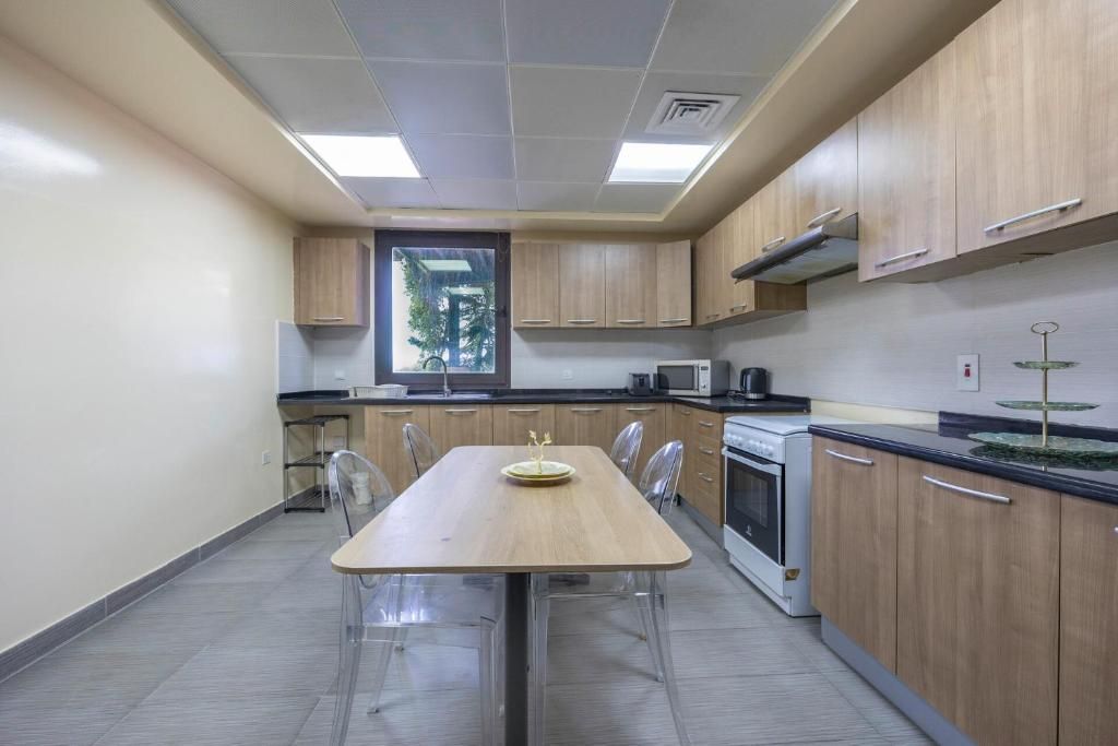 A modern kitchen with a central island, stainless steel appliances, and a window providing natural light.