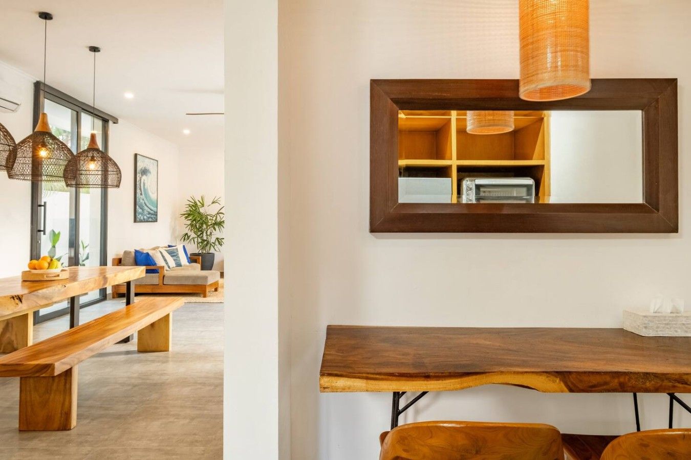 Un espace de restauration moderne avec une table en bois, des bancs et des luminaires suspendus.